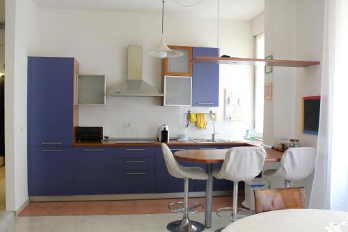 博洛尼亚Carbonara Apartment的厨房配有蓝色橱柜和桌椅