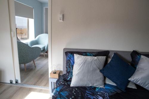 滨海卡特韦克kustappartementenkatwijk的客厅配有沙发、枕头和镜子