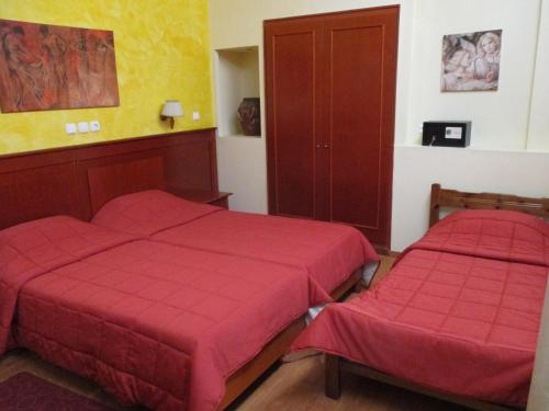 拉米亚黛尔塔酒店的红色床单的客房内的两张床