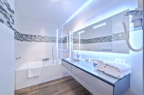 瑟内夫Au fil de l'eau的白色的浴室设有水槽和浴缸。
