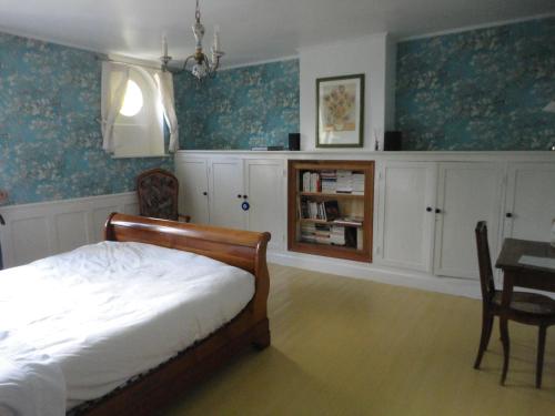 图尔奈Villa Tournesol的一间卧室配有一张床、一张桌子和橱柜