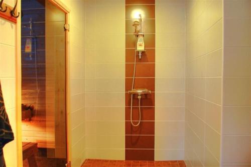 Ruokonen卡库塔克别墅度假屋的带淋浴的浴室(带瓷砖墙)