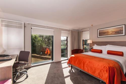 亨利昂泰晤士Greenlands Hotel的一间卧室配有一张床、一张书桌和一个窗户。