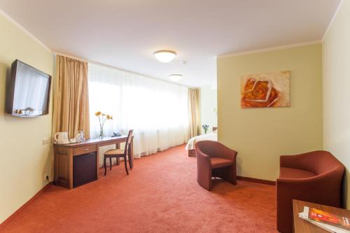 维尔纽斯维尔纽斯空中旅馆酒店的酒店客房配有书桌、床和电视。