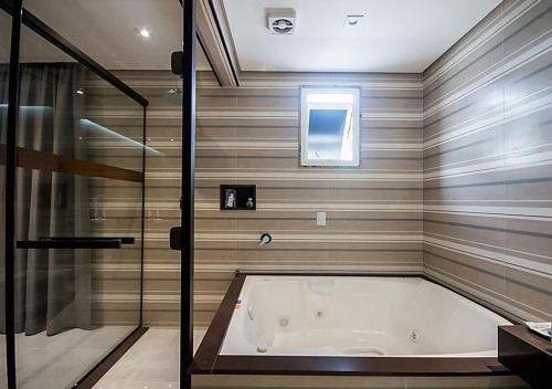 圣保罗加勒比汽车旅馆（仅限成人）的设有带浴缸和淋浴的浴室。