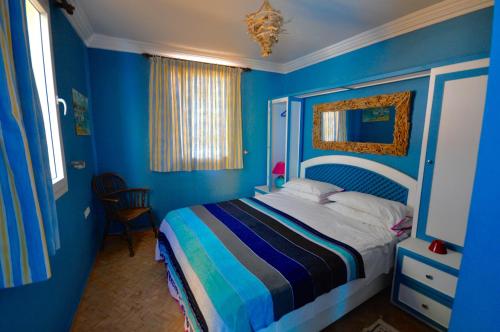 米勒福特Sallys的一间拥有蓝色墙壁的卧室和一张带条纹床罩的床