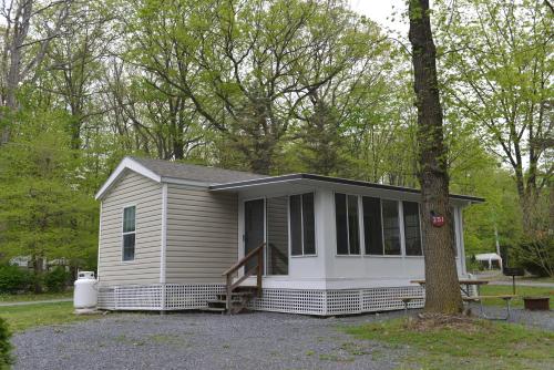 ShartlesvilleAppalachian Camping Resort Park Model 2的一个小房子,有门廊和一棵树