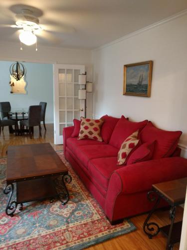 夏洛特University City Guest House的客厅配有红色的沙发和桌子