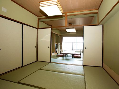 东伊豆町热川伊东园酒店的一间空房间,有门,还有一间房间,有桌子