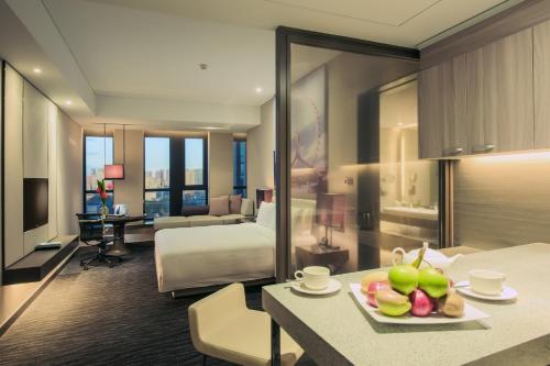 天津天津泛太平洋大酒店的酒店客房,配有床和一张带水果的桌子