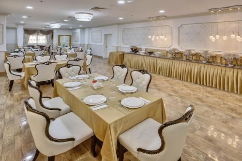 沙迦Royal Hotel的一间带桌椅的用餐室和一间酒吧