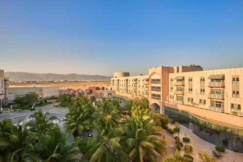 塞拉莱Salalah Gardens Hotel Managed by Safir Hotels & Resorts的享有棕榈树和建筑的城市美景