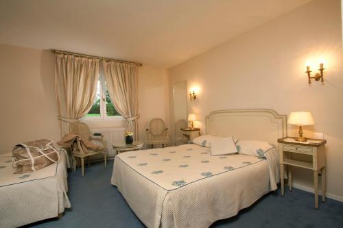 热夫雷尚贝尔坦艺术及风土条件之家酒店的一间卧室设有两张床、一把椅子和一个窗户。