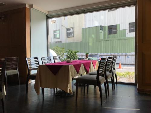 虎尾镇什叶派伊赫酒店的一间带桌椅和窗户的用餐室