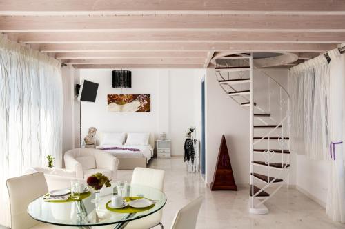 易莫洛林红月公寓的白色的客厅设有螺旋楼梯和玻璃桌