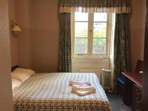 伦敦四星级酒店的一间卧室设有一张床和一个窗口