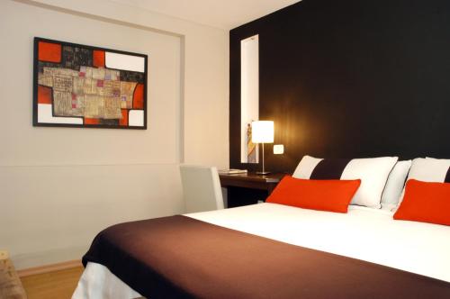 门多萨波希米亚精品酒店的一间卧室配有一张带红色枕头的床和一张书桌