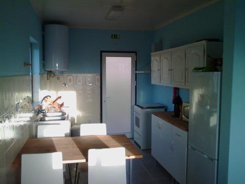 Faja GrandeCasa do Baixio的厨房设有蓝色的墙壁和白色的橱柜。