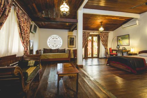 邦隆红土上的小屋酒店的一间卧室设有一张床和一间客厅。