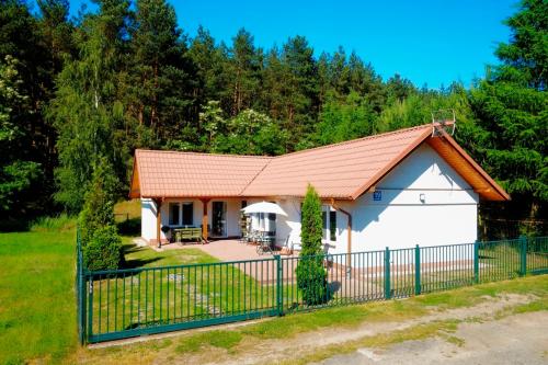 格但斯克Domek Letniskowy Pod Lasem的一间白色的小房子,有红色的屋顶