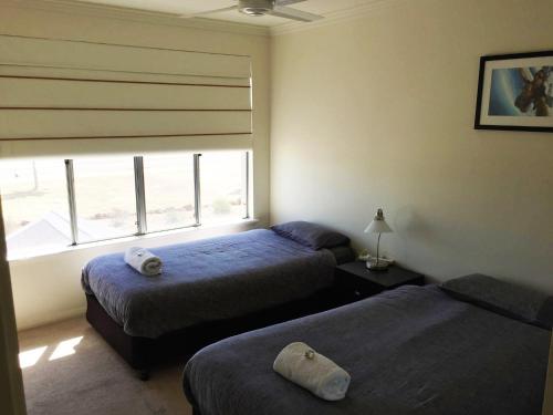 朱里恩湾Blue Sky Apartment的一间卧室设有两张床和一个美景窗户。