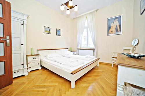 索波特Red Apartment Czyżewskiego by Grand Apartments的卧室设有一张白色大床和木地板
