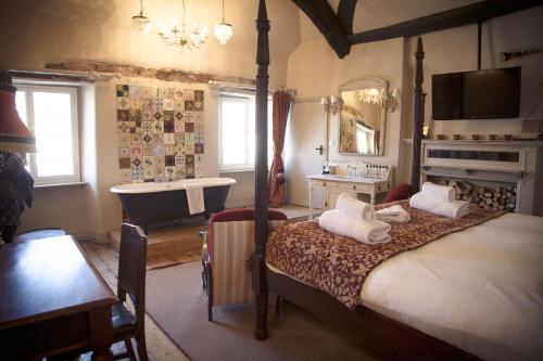 萨默顿白鹿宾馆的一间卧室配有一张床和一个水槽和一个浴缸