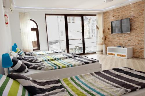 奥赫里德Ana's Apartments的卧室内的两张床,砖墙上配有电视