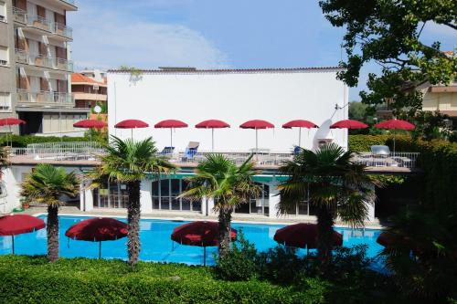 贝拉里亚-伊贾马里纳Hotel Nautic B&B的大楼前的带红伞的游泳池