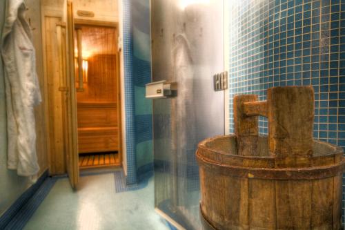 库马约尔Villa Novecento Romantic Hotel - Estella Hotel Collection的浴室设有蓝色瓷砖,配有旧木浴缸。