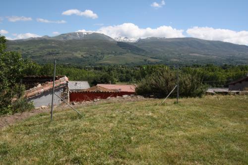 Solana de ávilaCasa Rural el Huerto的一片草场,背景是山