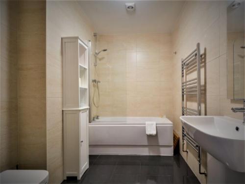 纽基SeaQuest 5的带浴缸、卫生间和盥洗盆的浴室