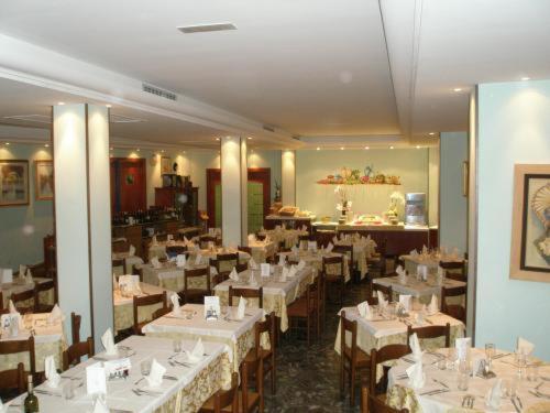 利多迪耶索罗美式酒店的用餐室配有桌椅和白色桌布