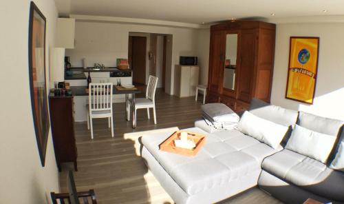 特里尔Ferienwohnung An der Pferdsweide的一间带白色沙发的客厅和一间厨房