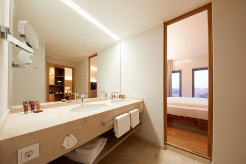 盖瑟克Hotel Rittergut Stoermede的一间带水槽和大镜子的浴室