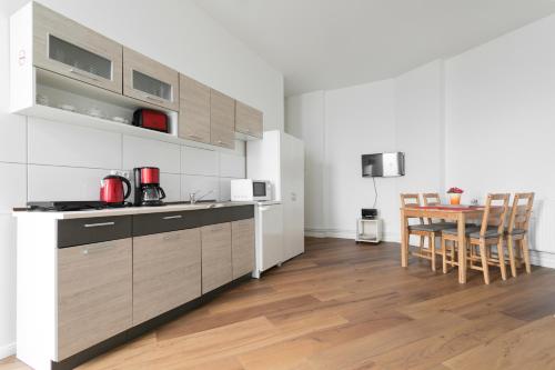 柏林City Studio Apartment for 4, near Sonnenallee的厨房铺有木地板,配有桌椅