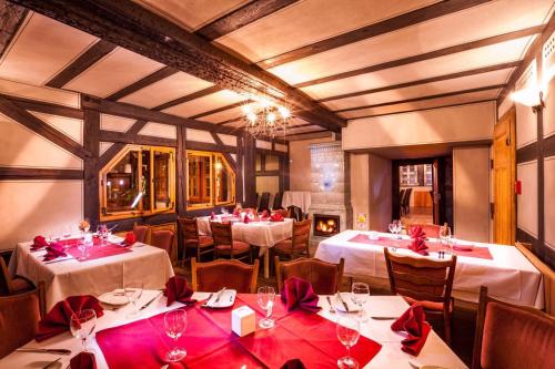 耶拿Hotel Haus im Sack的一间设有桌椅和红色弓的用餐室