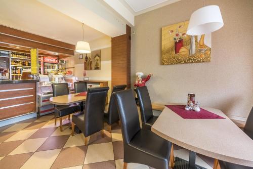 奥博尔尼基Hotel Doris的餐厅内带桌椅的用餐室