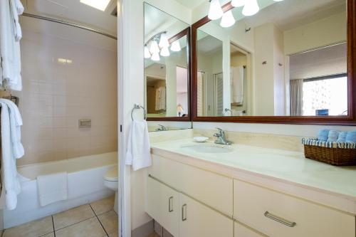 檀香山夏威夷阳光假日公寓的一间带水槽、浴缸和镜子的浴室