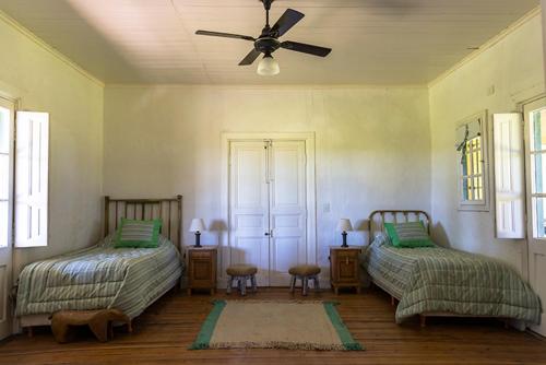 查斯科穆斯Estancia La Margarita的一间卧室配有两张床和吊扇