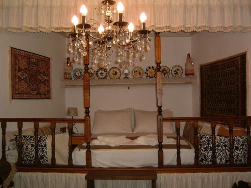 哈尔基岛Yiayia's Home的一间卧室配有一张带吊灯的床