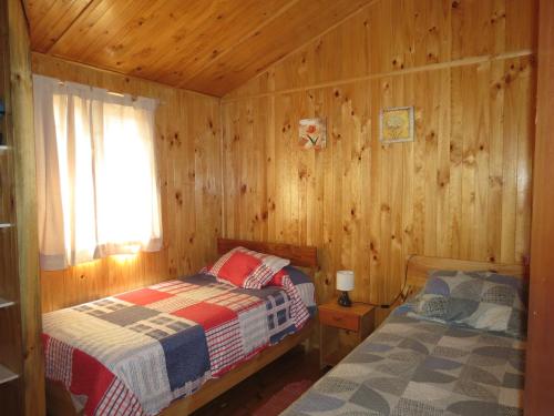 奥尔穆埃Cabañas Antilhue的小木屋内一间卧室,配有两张床