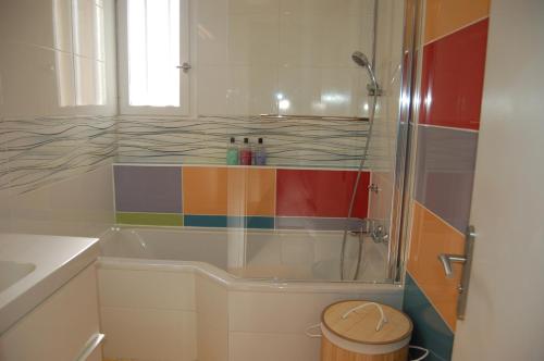 GaronsLa Maison de Peggy的一间带浴缸和彩虹淋浴的浴室