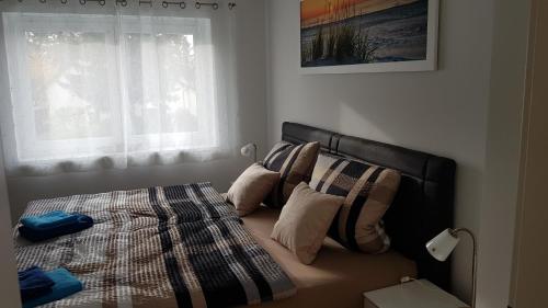 莱比锡Ferien-Haus-Leipzig的卧室配有带枕头的床铺和窗户。