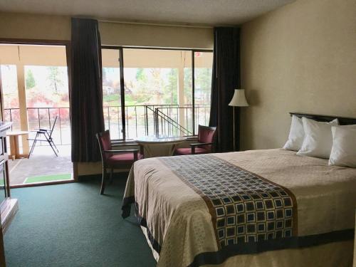莱文沃思River's Edge Lodge的酒店客房设有一张床和一个阳台。