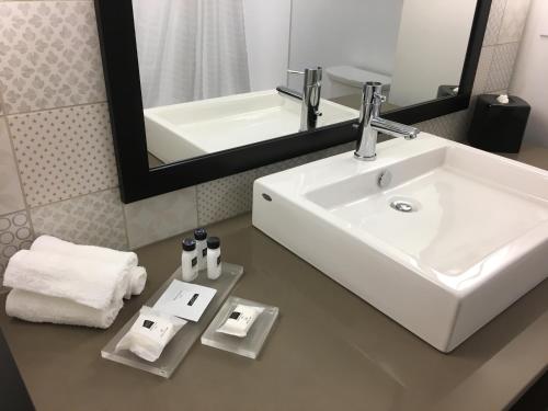 大洋城Country Inn & Suites by Radisson Ocean City的浴室设有白色水槽和镜子
