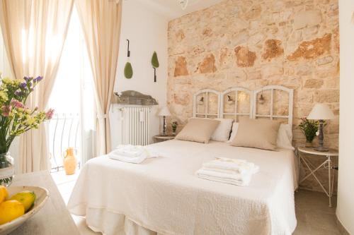 图里Manidibianco Apulian Relaxing Stay的卧室配有白色床和毛巾