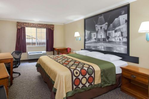 洛杉矶洛杉矶市区速8酒店的酒店客房设有一张床铺,墙上挂着一张大照片