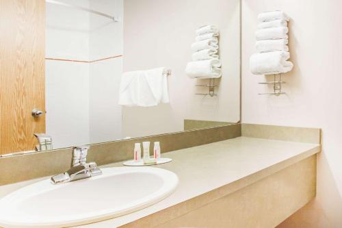 Meadow Lake草甸湖速8酒店的浴室配有盥洗盆、镜子和毛巾