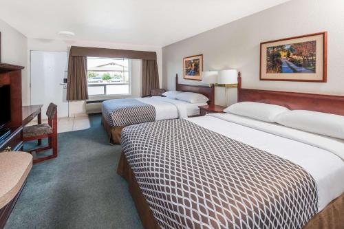 High River高河速8酒店的酒店客房设有两张床和电视。